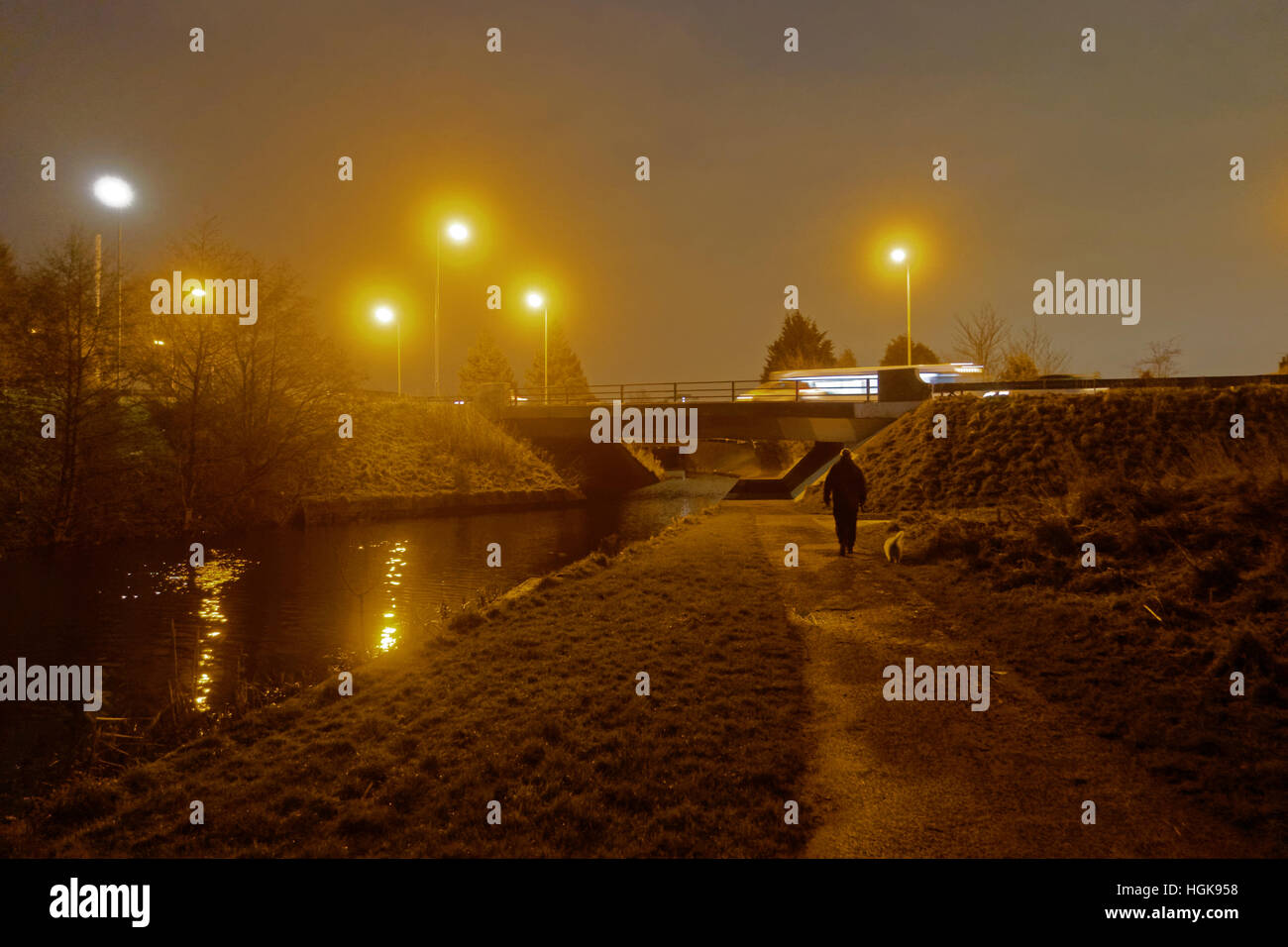 Man Walking dog tard dans la nuit, pont-route et nuit canal canal de Clyde, Glasgow Banque D'Images