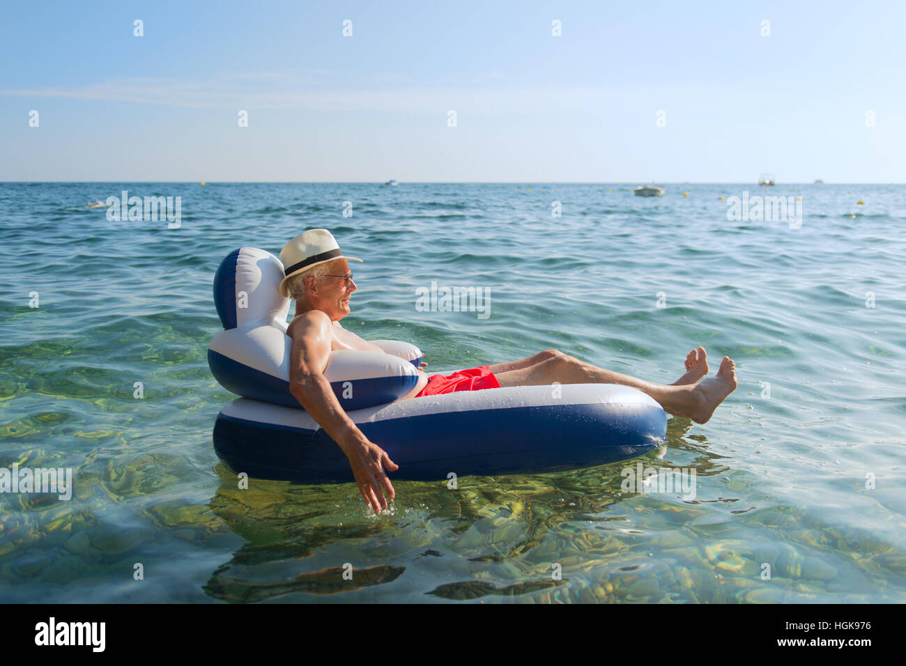 Senior en vacances flottant à la présidence dans la mer Banque D'Images