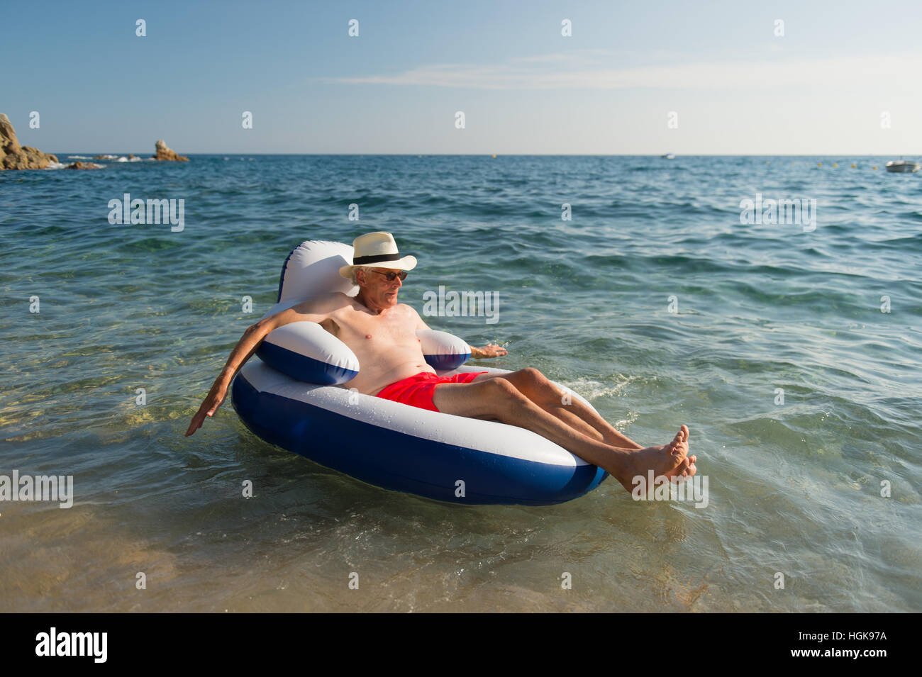 Senior en vacances flottant à la présidence dans la mer Banque D'Images