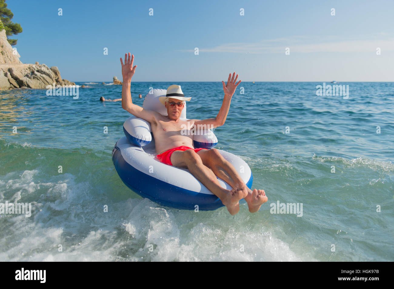 Senior en vacances flottant à la présidence dans la mer Banque D'Images