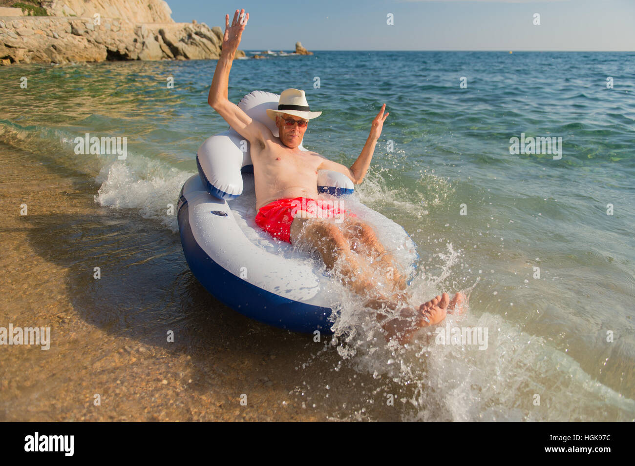 Senior en vacances flottant à la présidence dans la mer Banque D'Images