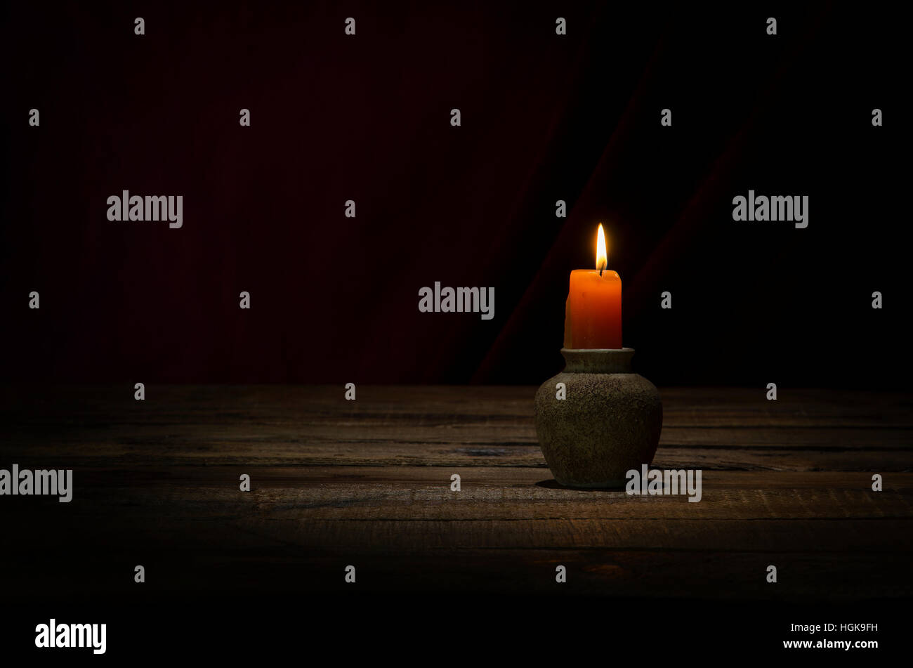 Bougie allumée dans une sombre sur table en bois. Banque D'Images