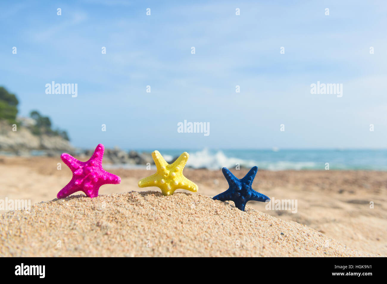 Jaune rose et bleu des étoiles de debout à la plage Banque D'Images