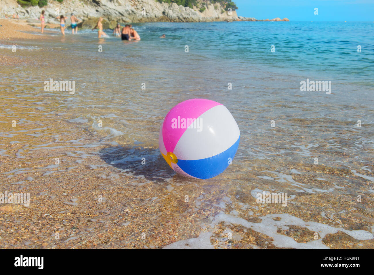 Ballon de plage gonflable coloré jouant avec le surf et la mer Banque D'Images