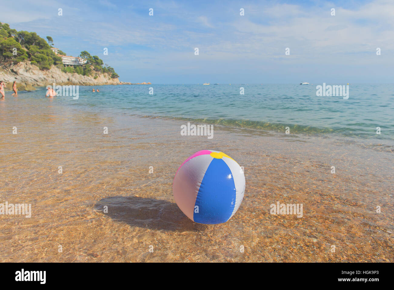 Ballon de plage gonflable coloré jouant avec le surf et la mer Banque D'Images