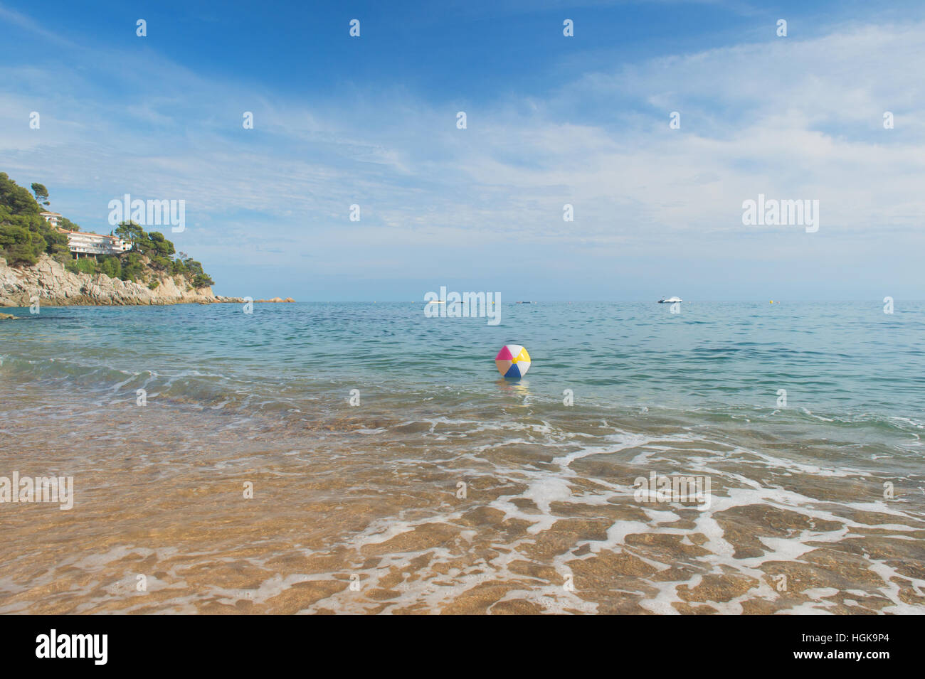 Ballon de plage gonflable coloré jouant avec le surf et la mer Banque D'Images