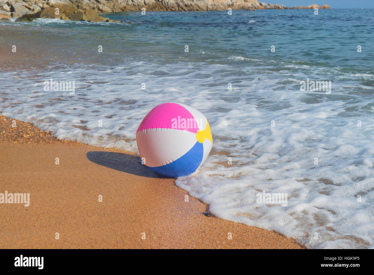 Ballon de plage gonflable coloré jouant avec le surf et la mer Banque D'Images