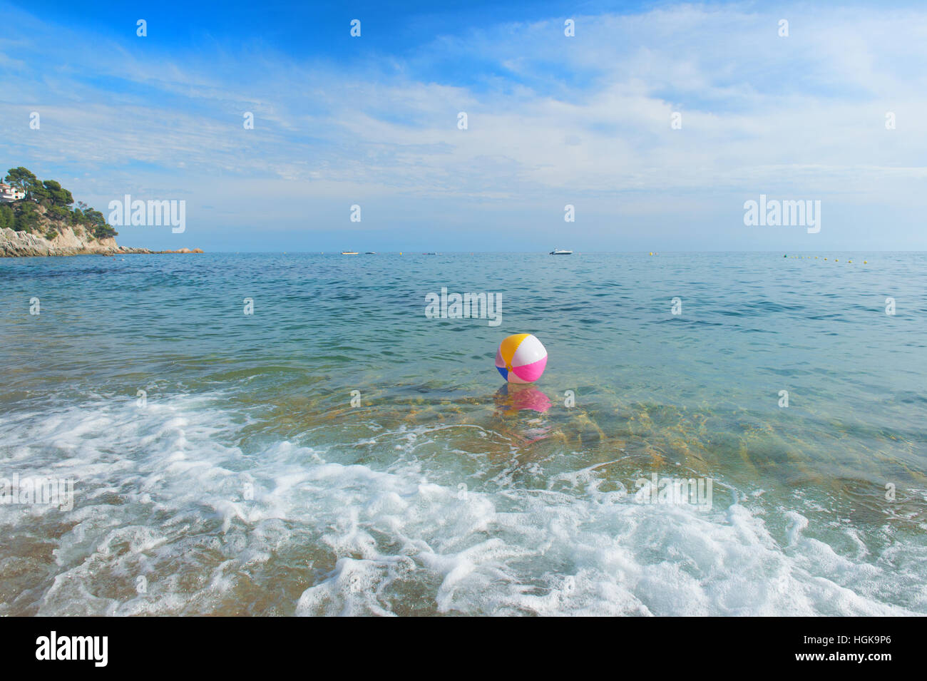 Ballon de plage gonflable coloré jouant avec le surf et la mer Banque D'Images