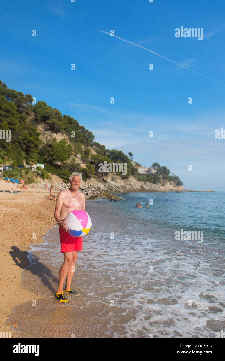L'homme jouant avec ballon gonflable à la plage Banque D'Images