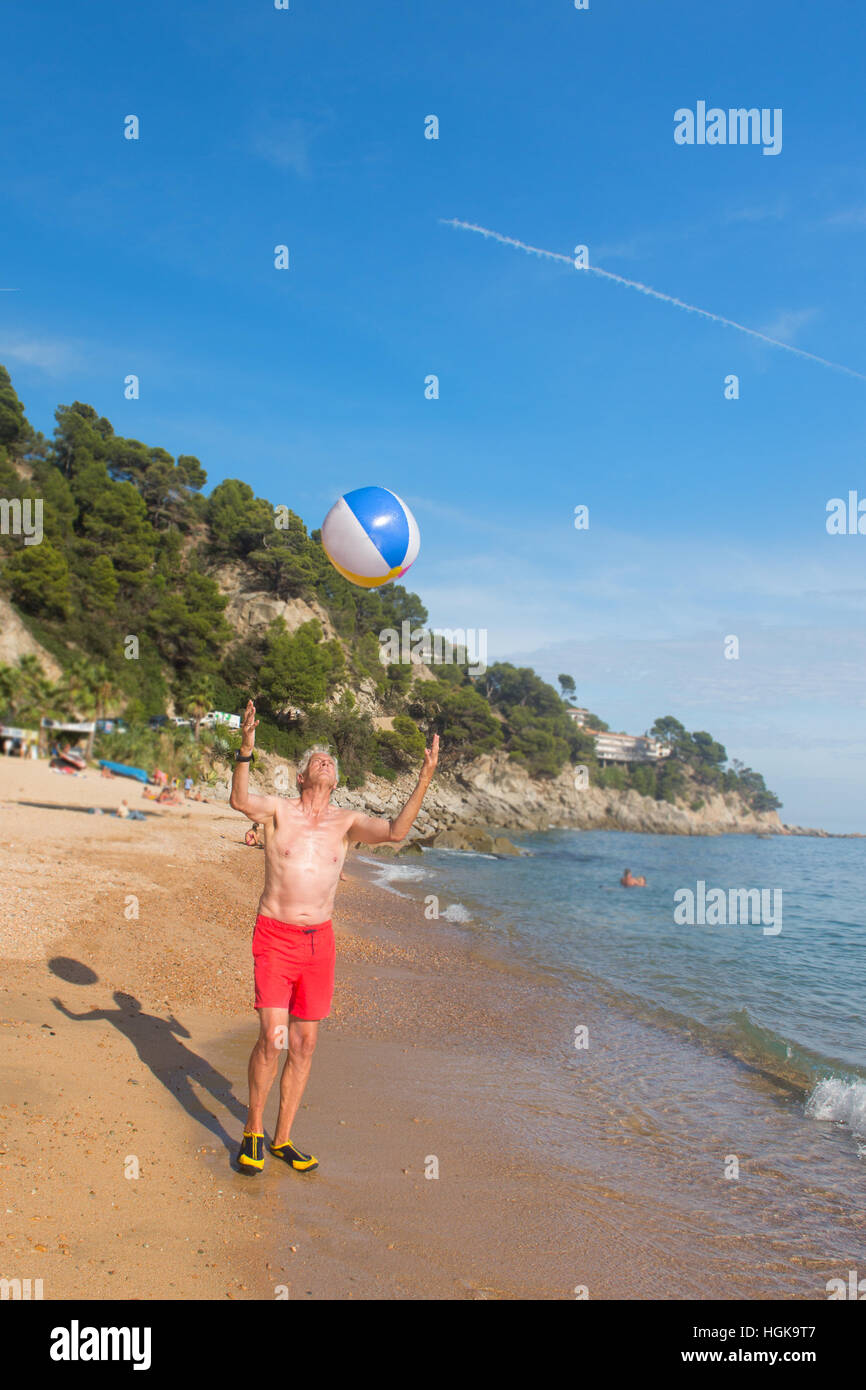 L'homme jouant avec ballon gonflable à la plage Banque D'Images