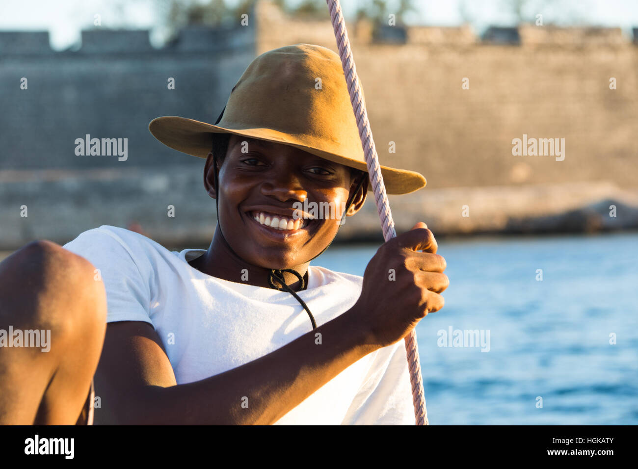 Jeune homme sur un dhow en face du fort, l'île de Mozambique (Ilha de Mocambique), Mozambique Banque D'Images