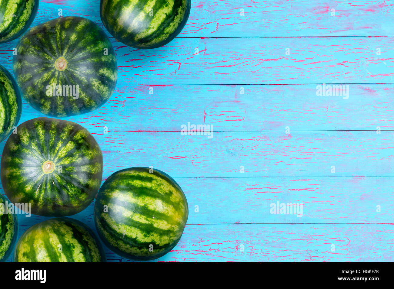 Weathered fond bleu avec des melons ronds empilés sur un côté. Inclut l'espace de copie pour concept à propos des aliments frais. Banque D'Images
