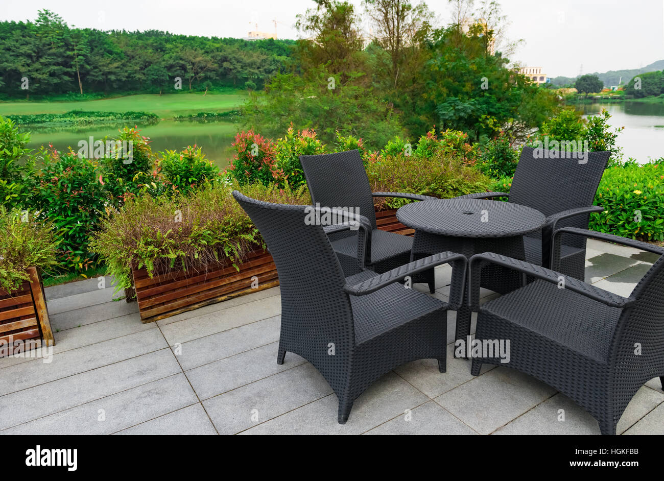 Canapé en rotin et table situé dans un jardin avec vue sur le lac Banque D'Images