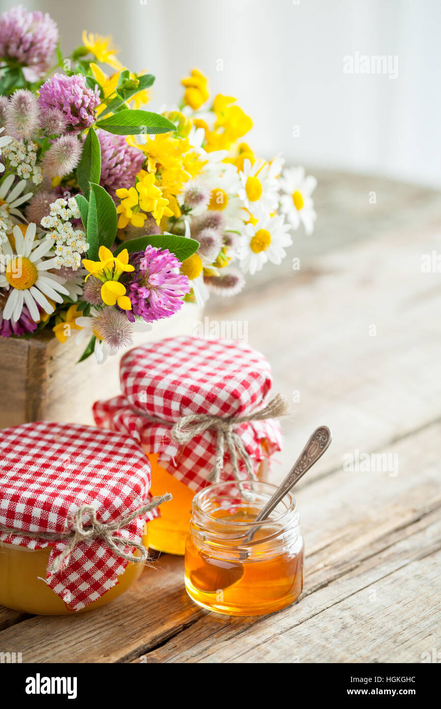 Pots de miel et herbes de guérison d'été bouquet sur table. Focus sélectif. Banque D'Images