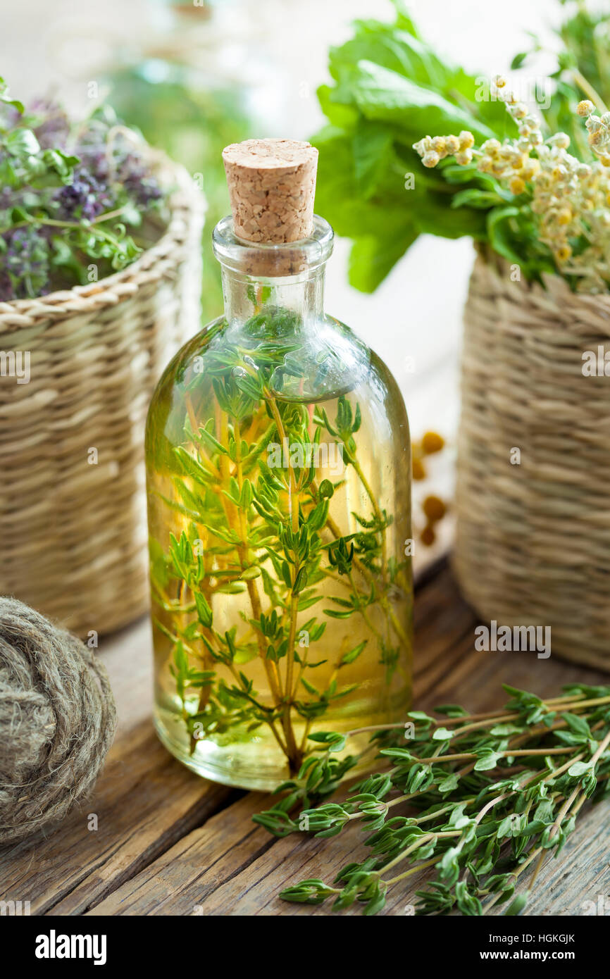 Bouteille d'huile essentielle de thym ou de l'infusion et panier avec des  herbes de guérison Photo Stock - Alamy