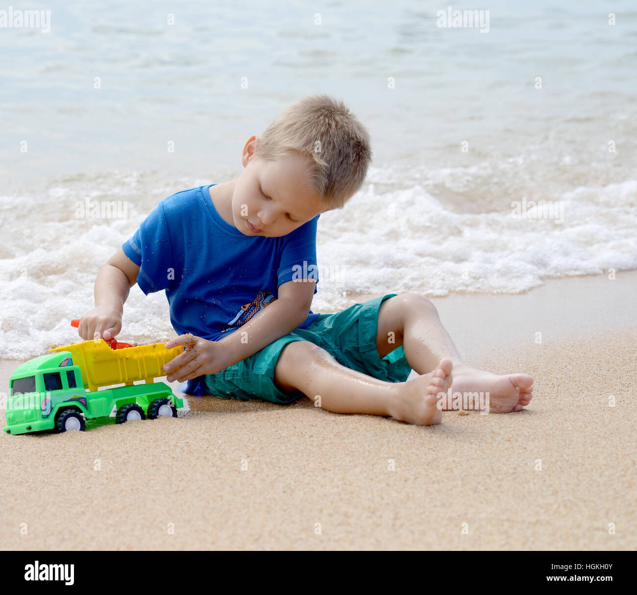 Petit Garçon jouant avec des jouets de plage on tropical beach Banque D'Images