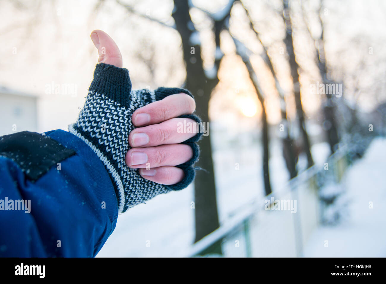 Main mâle showing Thumbs up à l'extérieur des gants hiver Banque D'Images