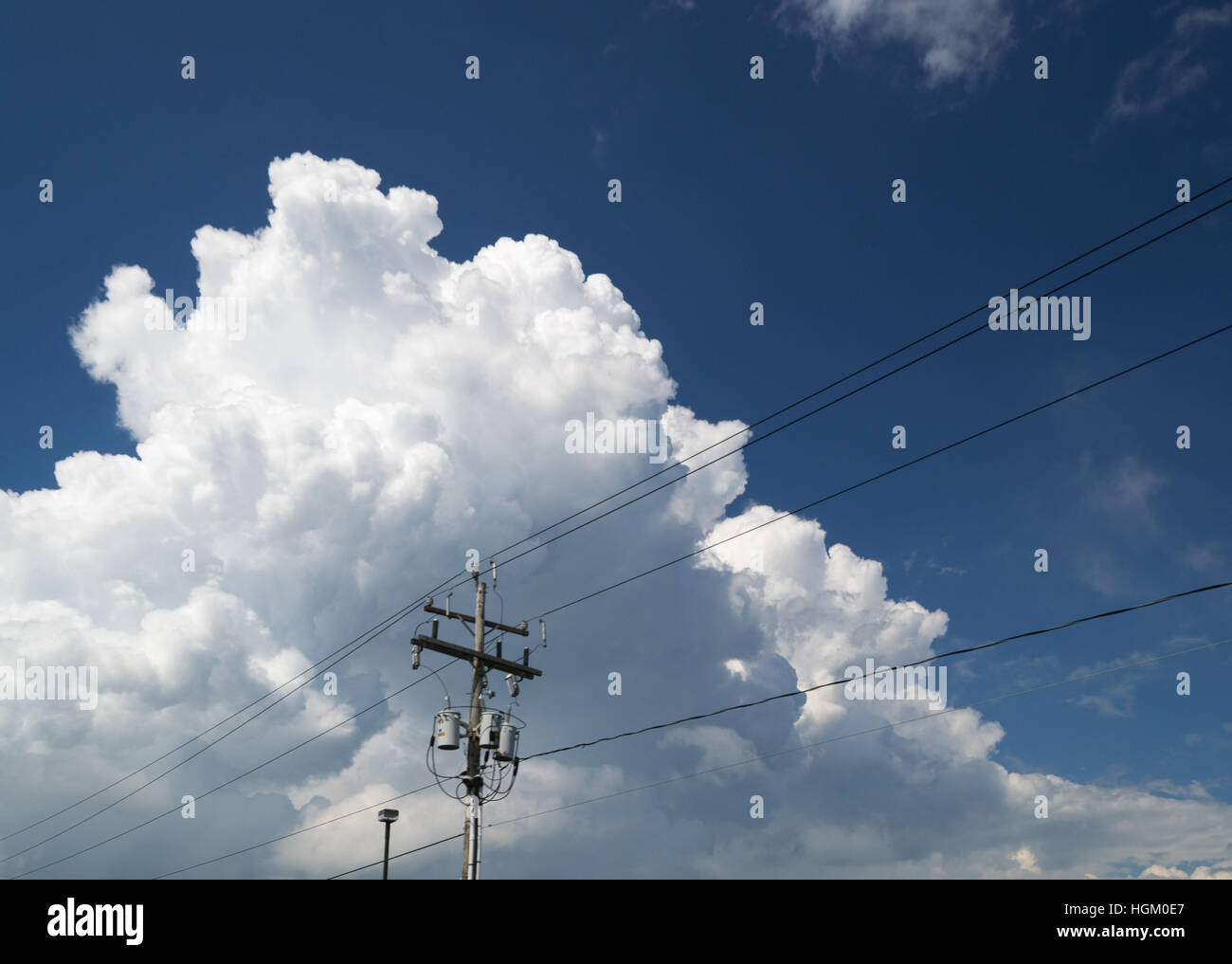 De gros nuages derrière une colonne d'alimentation Banque D'Images