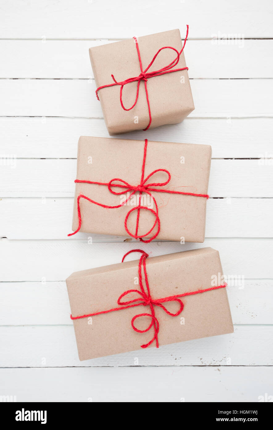 Noël brun rustique paquet papier attachés avec des chaînes. Fond de bois blanc. Banque D'Images