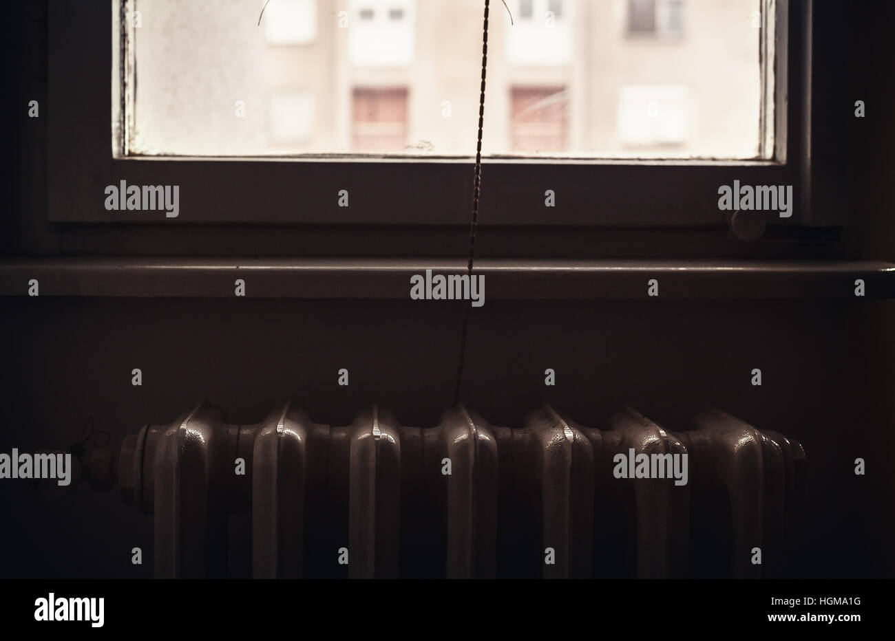 Détails de vie, vue rapprochée d'un ancien radiateur derrière la fenêtre. Banque D'Images
