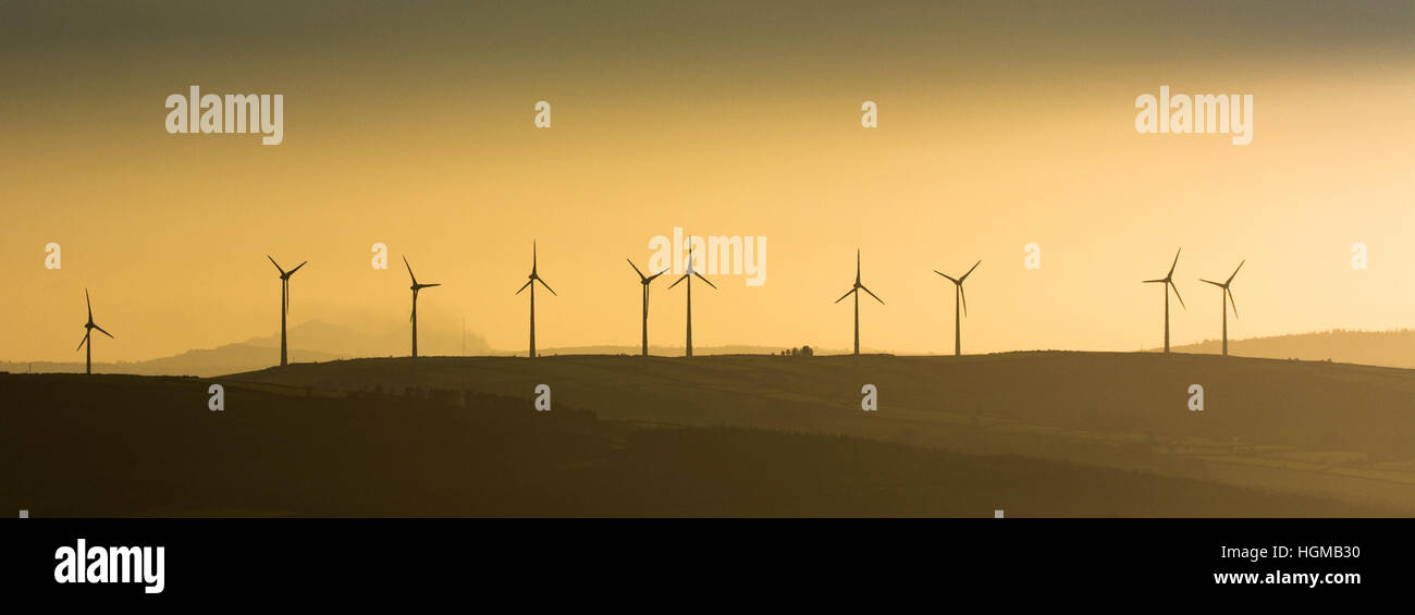 Éoliennes géantes à l'heure d'or le long de la crête d'une colline dans le Blackstairs mountains dans le sud-est de l'Irlande Banque D'Images