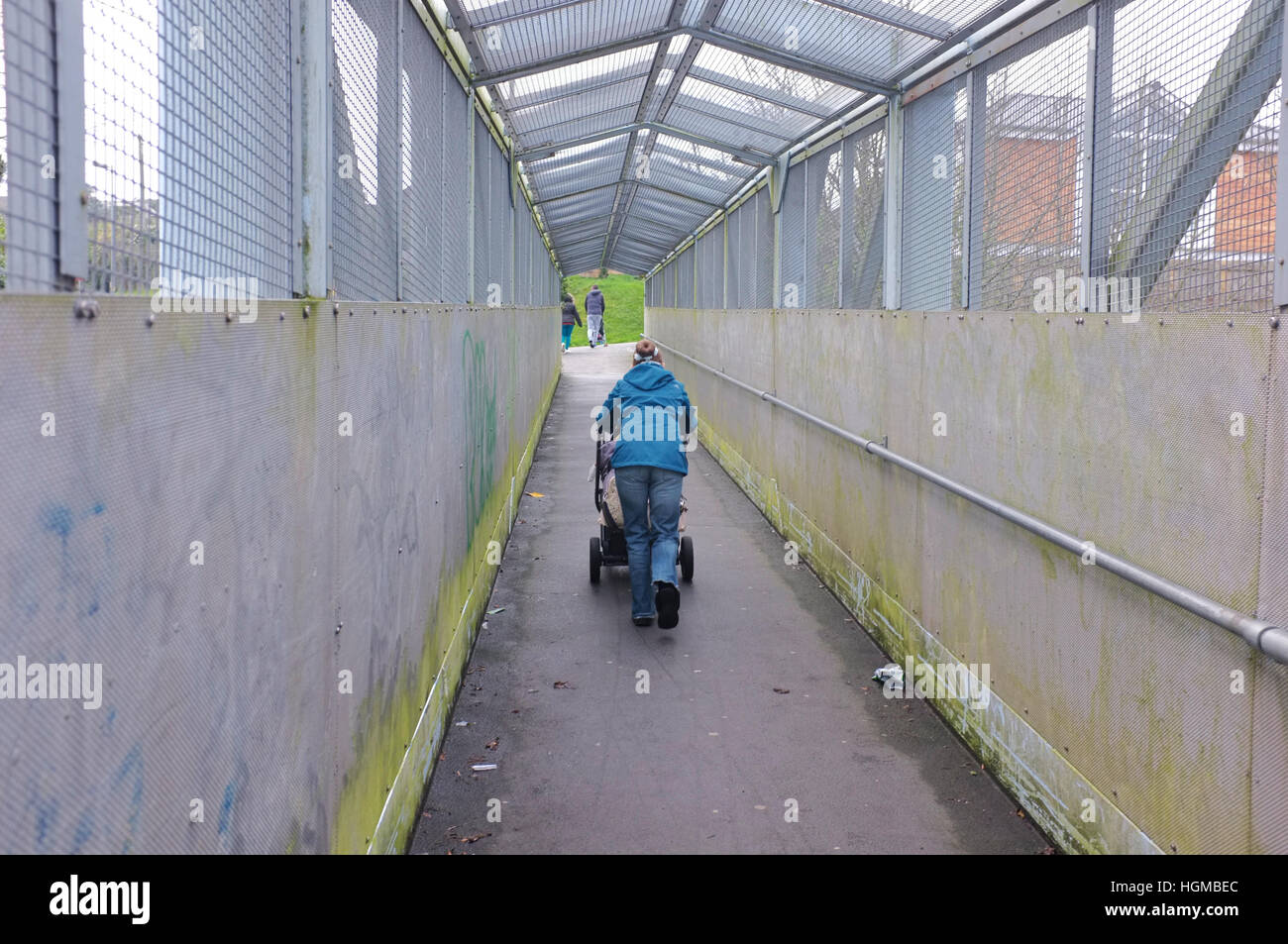 Une femme pousse une poussette sur un pont à Penryn, Cornwall en hiver. Banque D'Images