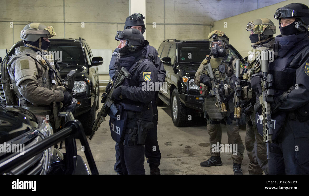 Les membres d'une unité spéciale de la police (Sondereinsatzkraefte, SEK, vêtu de vert) et les forces spéciales (Spezialkraefte) de la police de Saxe, qui ont été émis avec le nouvel équipement, photographié devant un véhicule de police blindée à Dresde, Allemagne, 11 janvier 2017. La force a été délivré avec sept Toyota Land Cruiser V8 véhicules, ainsi qu'une gamme d'équipement de protection. Photo : Arno Burgi/dpa-Zentralbild/dpa Banque D'Images