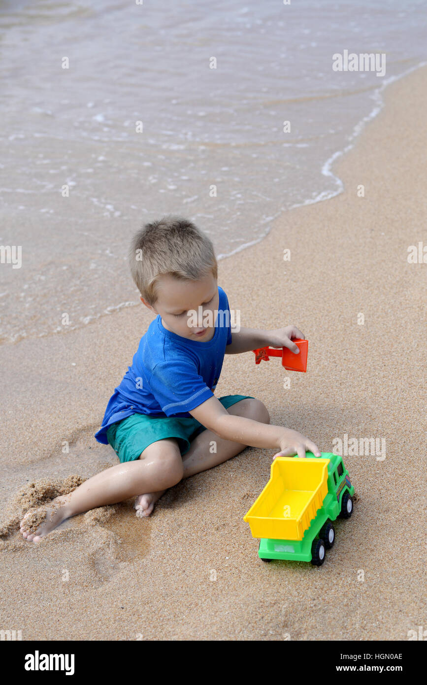 Petit Garçon jouant avec des jouets de plage on tropical beach Banque D'Images