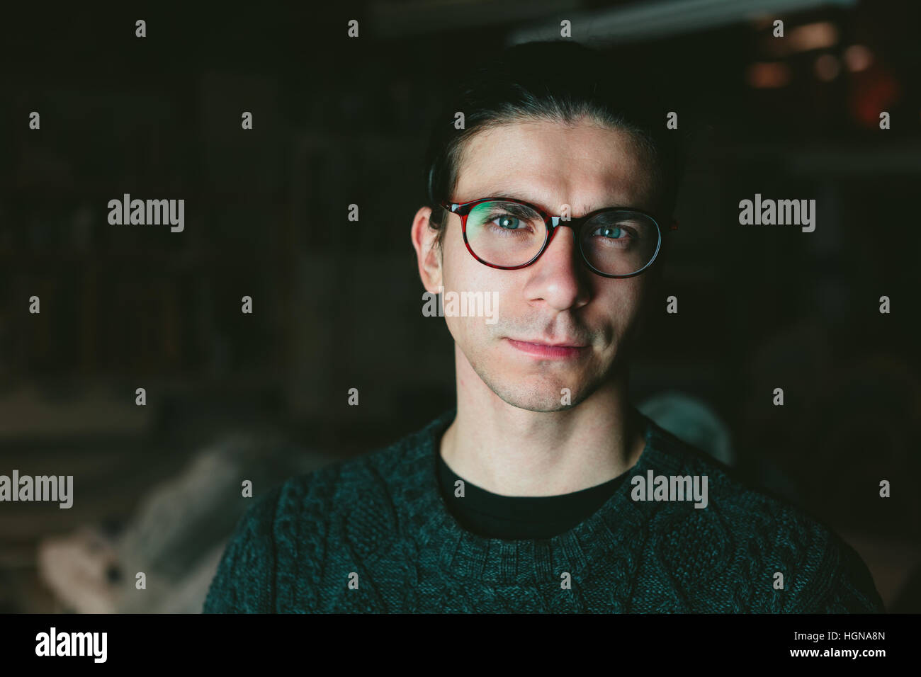 Jeune beau mec avec des lunettes sur fond sombre Banque D'Images