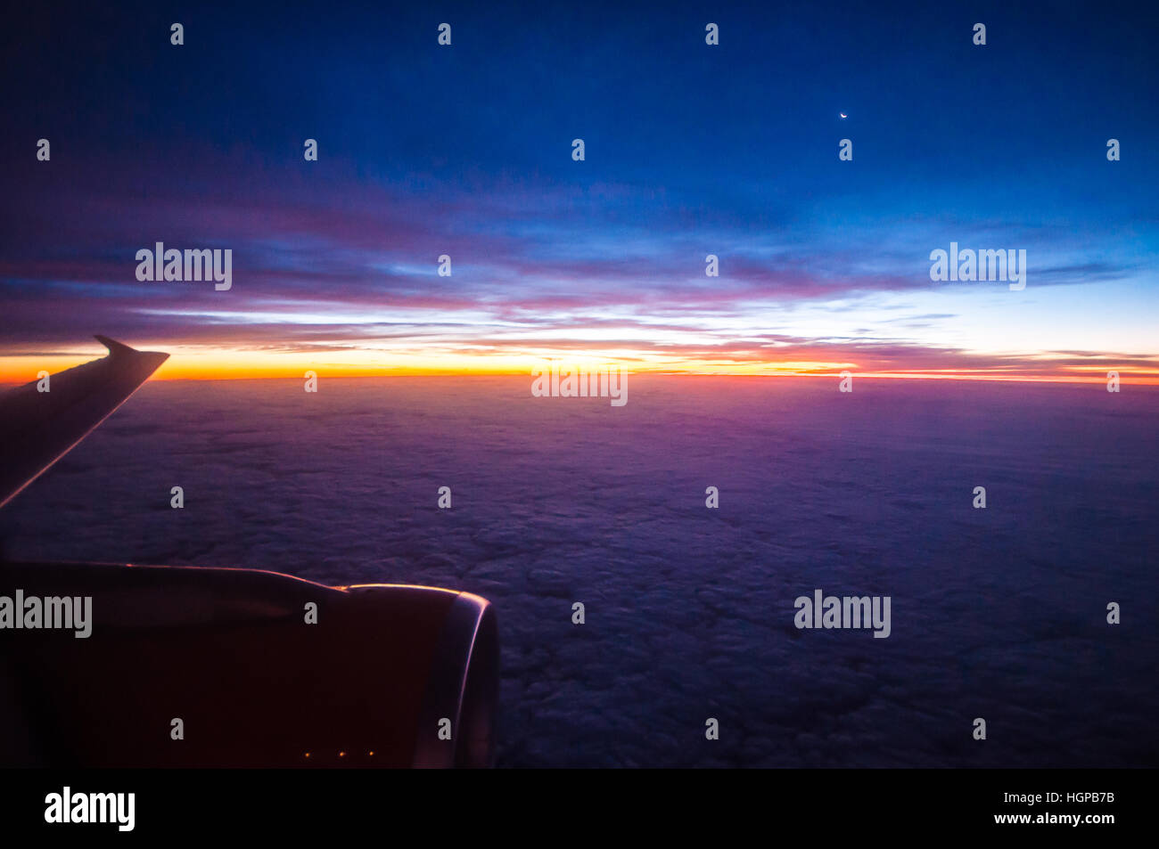 Vue d'un lever de soleil depuis la fenêtre d'un avion Airbus A320 easyJet au-dessus de l'Europe, avec la lune et un moteur en vue. Dawn Banque D'Images