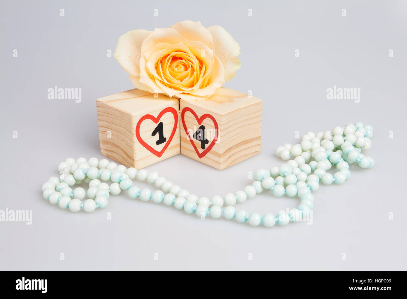 Cubes en bois, avec 14e , coeurs, rose et perles. Banque D'Images