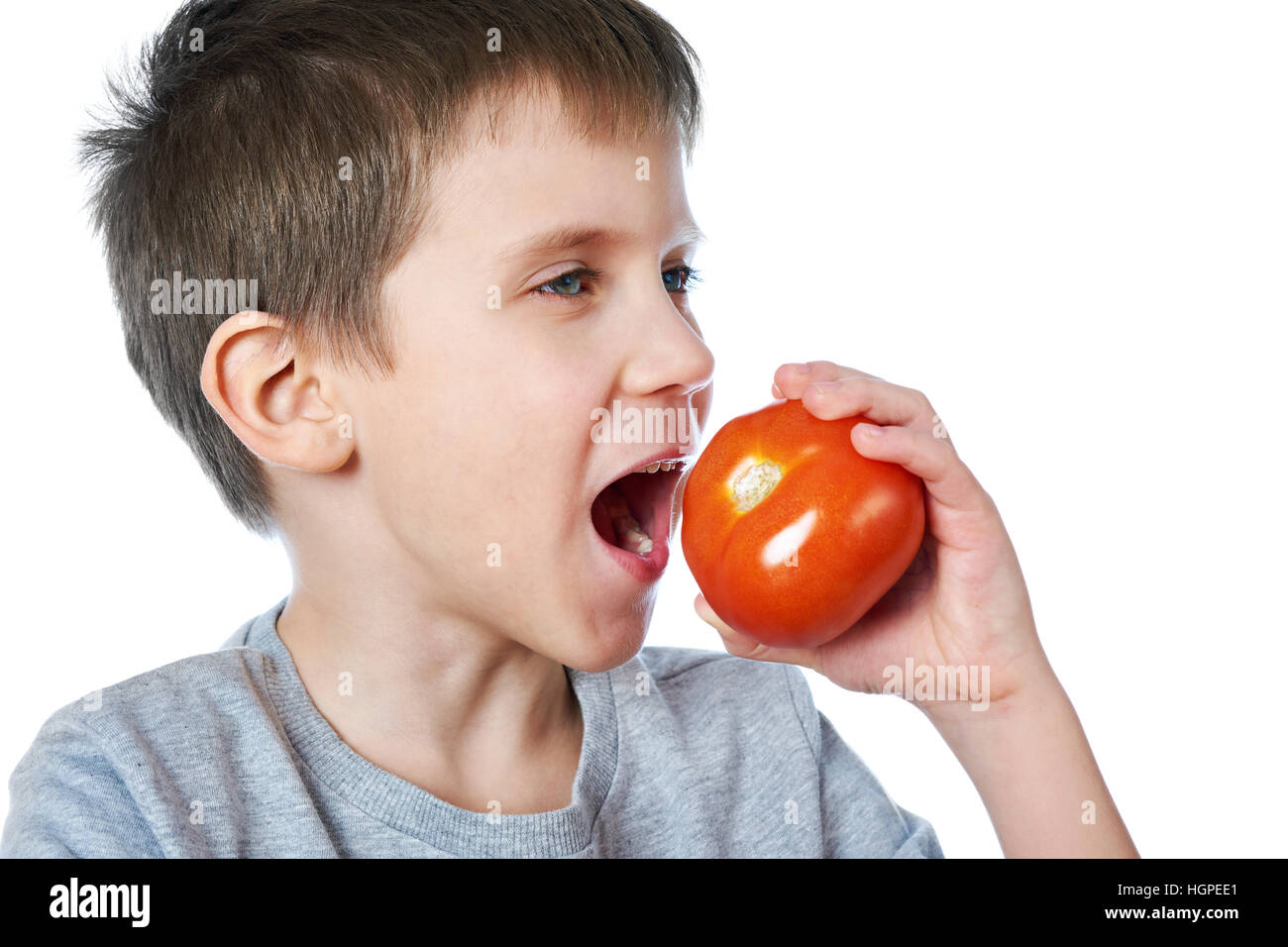 Petit garçon joyeux avec une tomate blanc isolé Banque D'Images