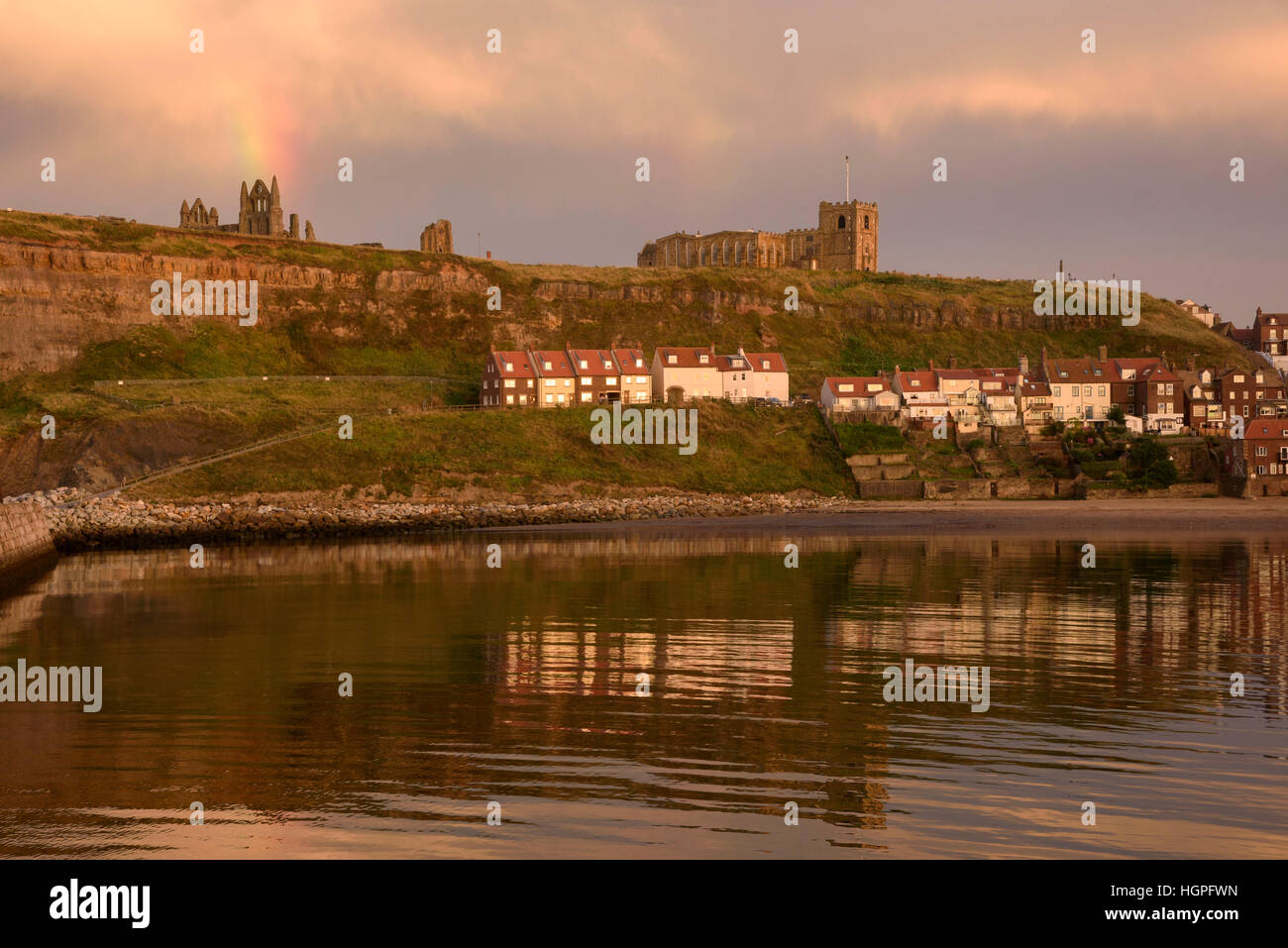 Vue de la falaise Est (maisons, Eglise St Mary, Abbey ruins et rainbow) reflète dans la mer - Whitby, North Yorkshire, GB. Banque D'Images