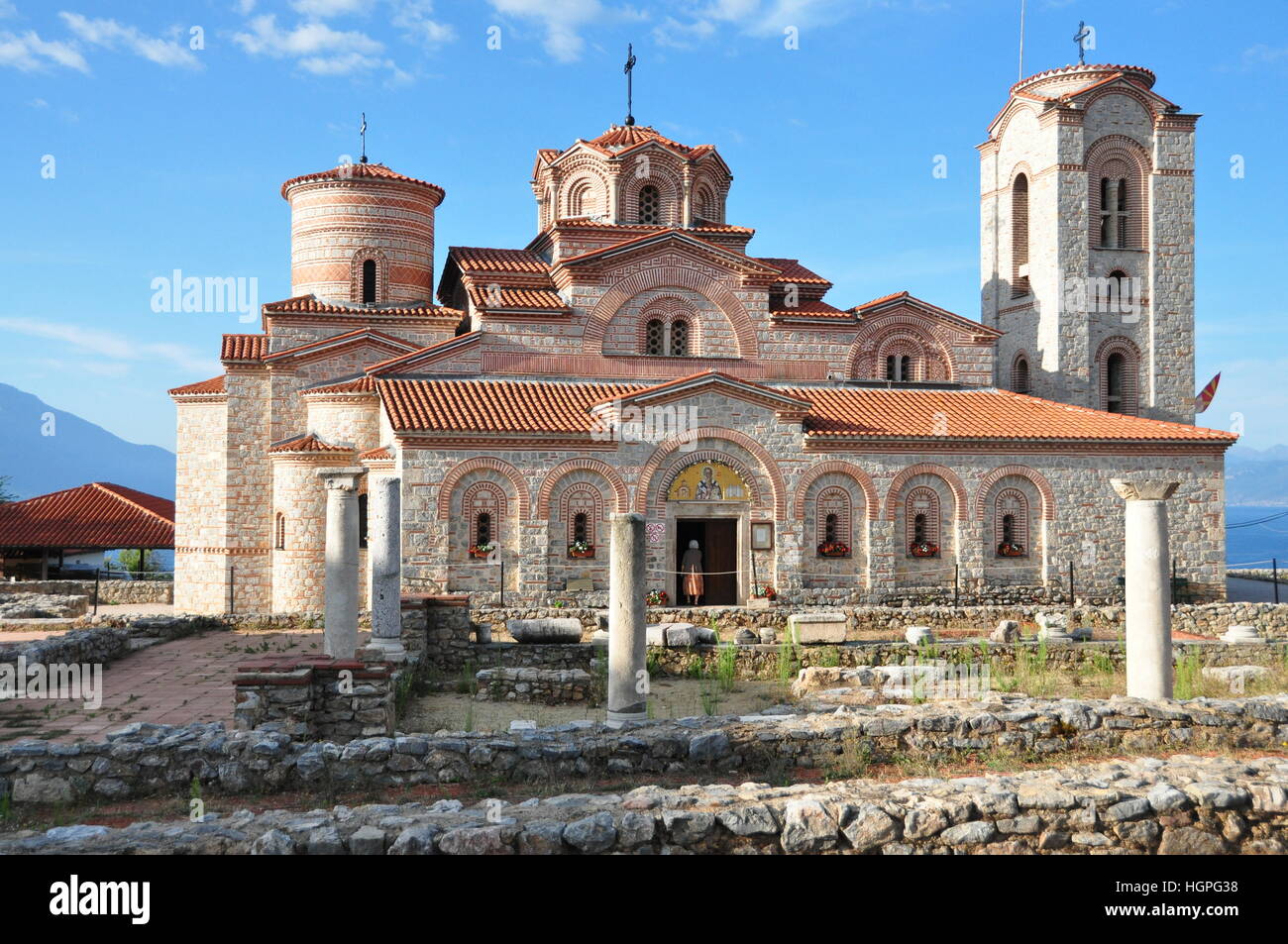 Beau mur en pierre traditionnelle de l'église macédonienne orthodoxe au lever du soleil avec toit de tuiles orange et les détails et ciel bleu Banque D'Images