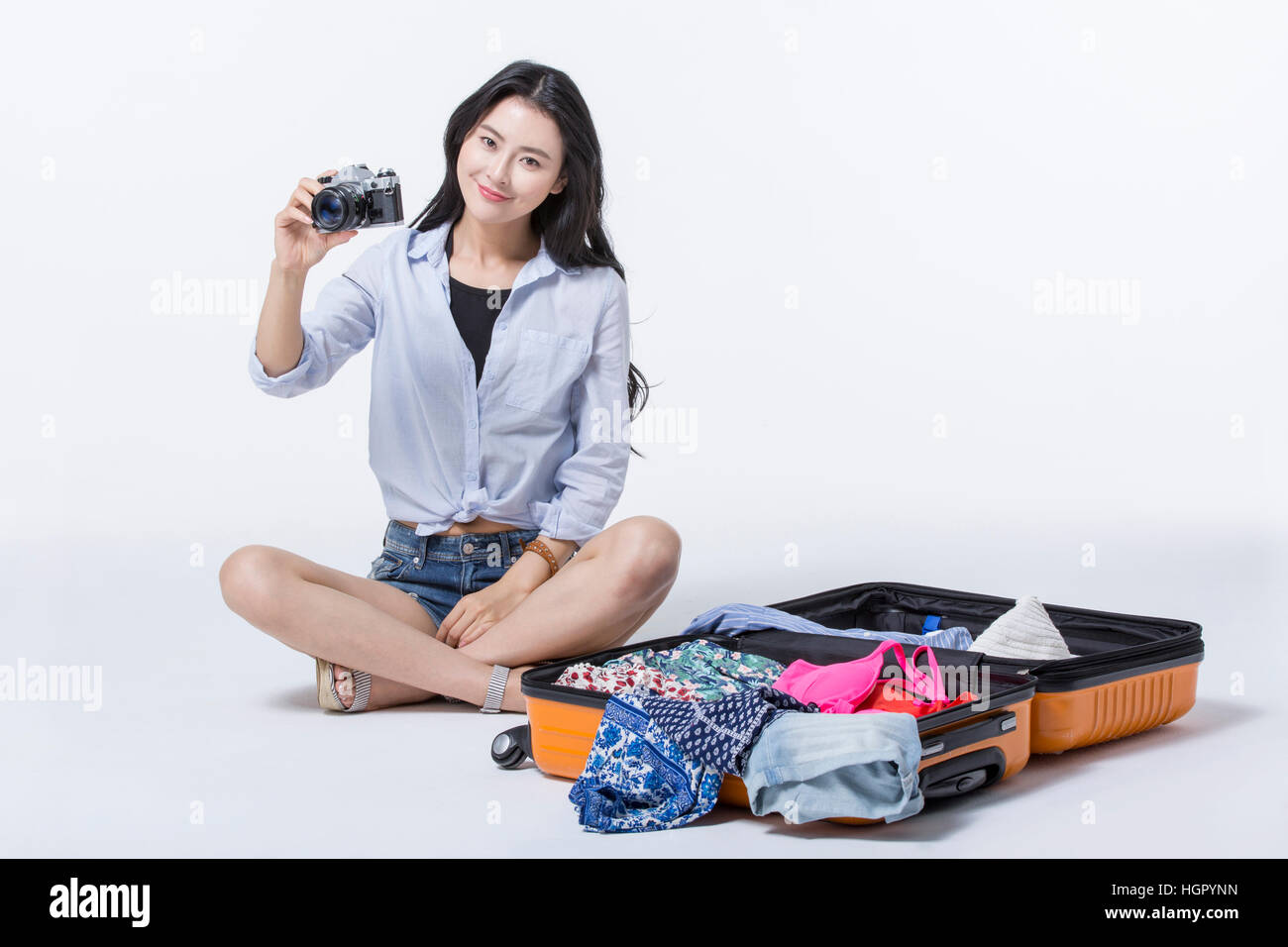 Young smiling woman sitting with camera Banque D'Images