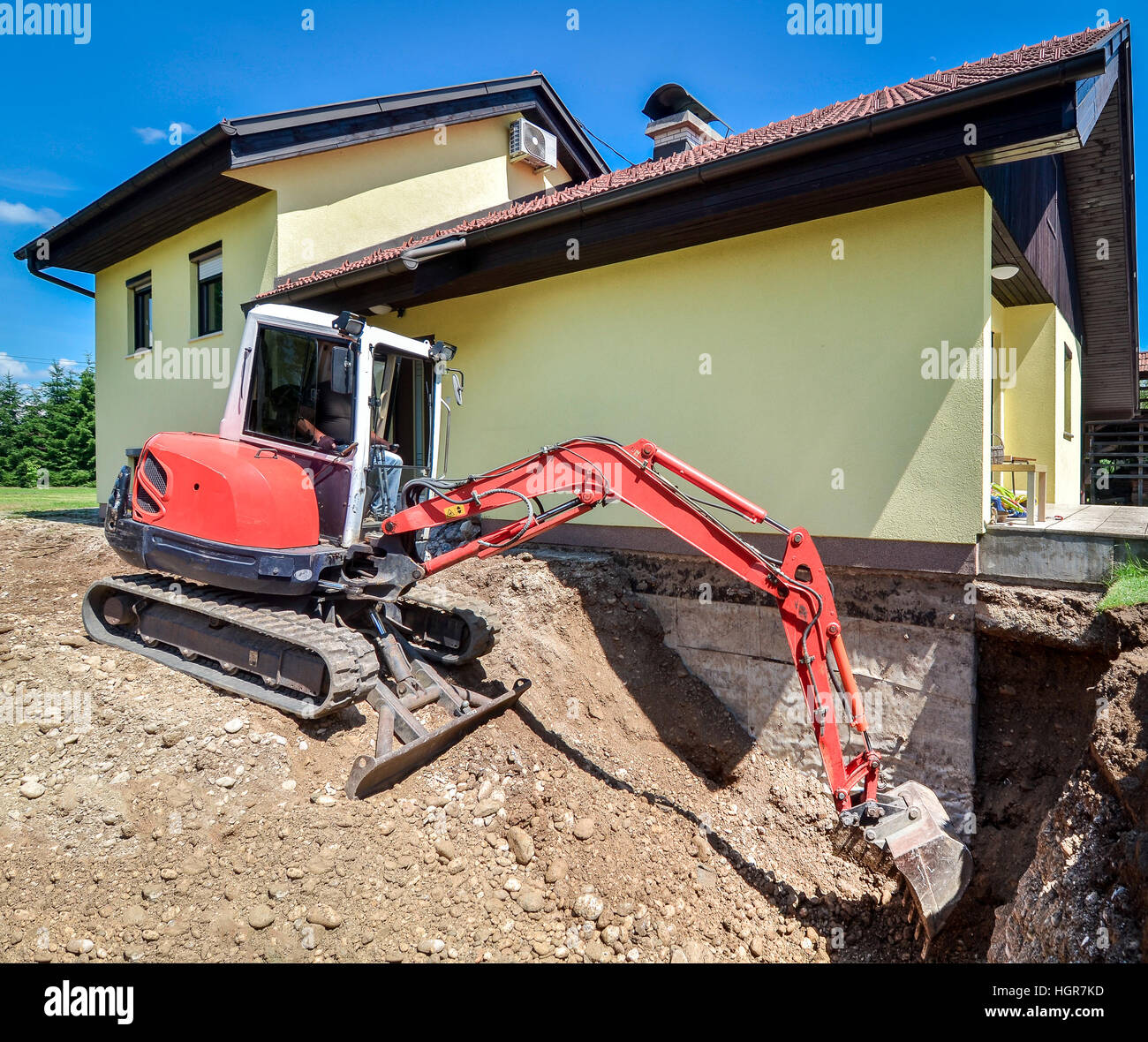 Une maison familiale est en cours de reconstruction avec l'aide d'une excavatrice Banque D'Images