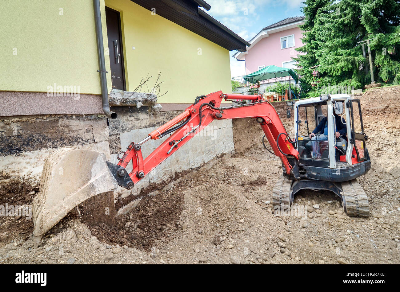 Une maison familiale est en cours de reconstruction avec l'aide d'une excavatrice Banque D'Images