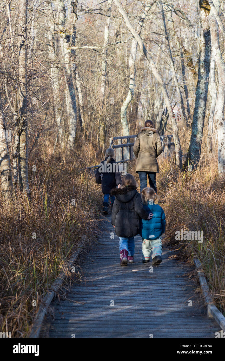 Mère et 3 enfants Trois enfants filles sur voie passerelle sentier sentier Marais de Lavours Réserve naturelle nationale. France Banque D'Images