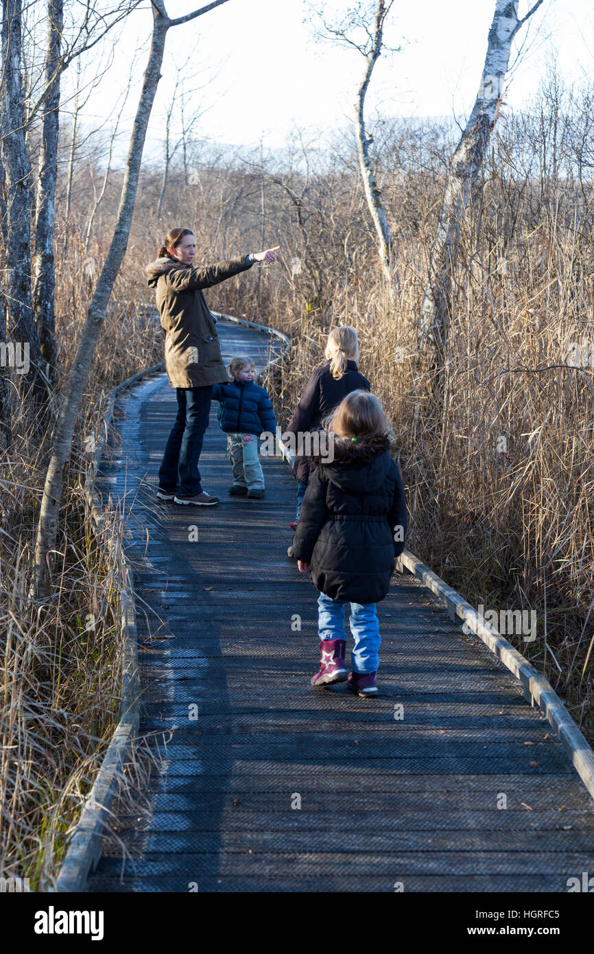 Mère et 3 enfants Trois enfants filles sur voie passerelle sentier sentier Marais de Lavours Réserve naturelle nationale. France Banque D'Images