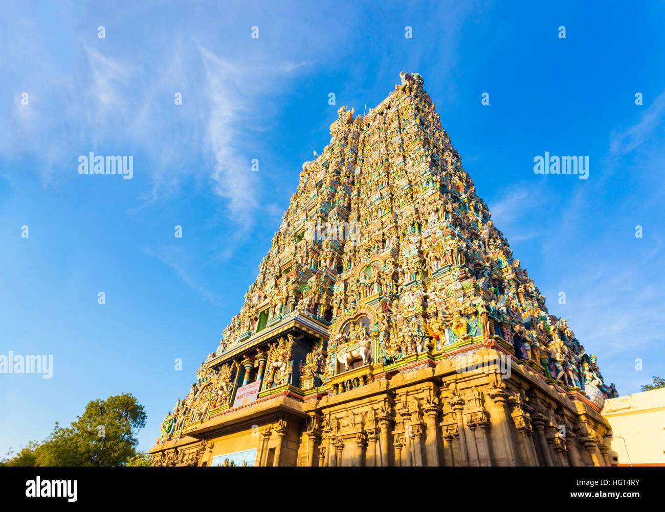 West Tower Gateway de Meenakshi Amman Temple couvert de statues de dieux colorés sur un ciel bleu journée à Madurai Banque D'Images