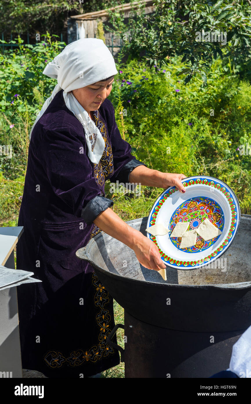 La préparation de la femme kazakh locale traditionnelle tandyr pain, Shymkent, Kazakhstan, Région du Sud, l'Asie centrale, pour un usage éditorial uniquement Banque D'Images