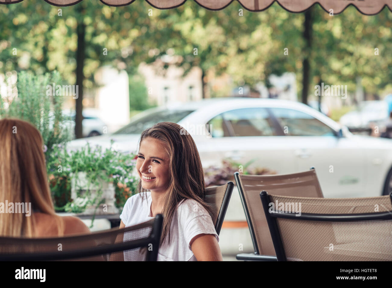 Woman chatting at a sidewalk cafe Banque D'Images