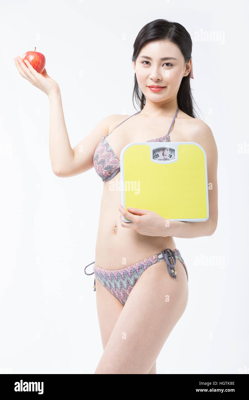 Young woman in bikini posing avec Apple et une échelle Banque D'Images