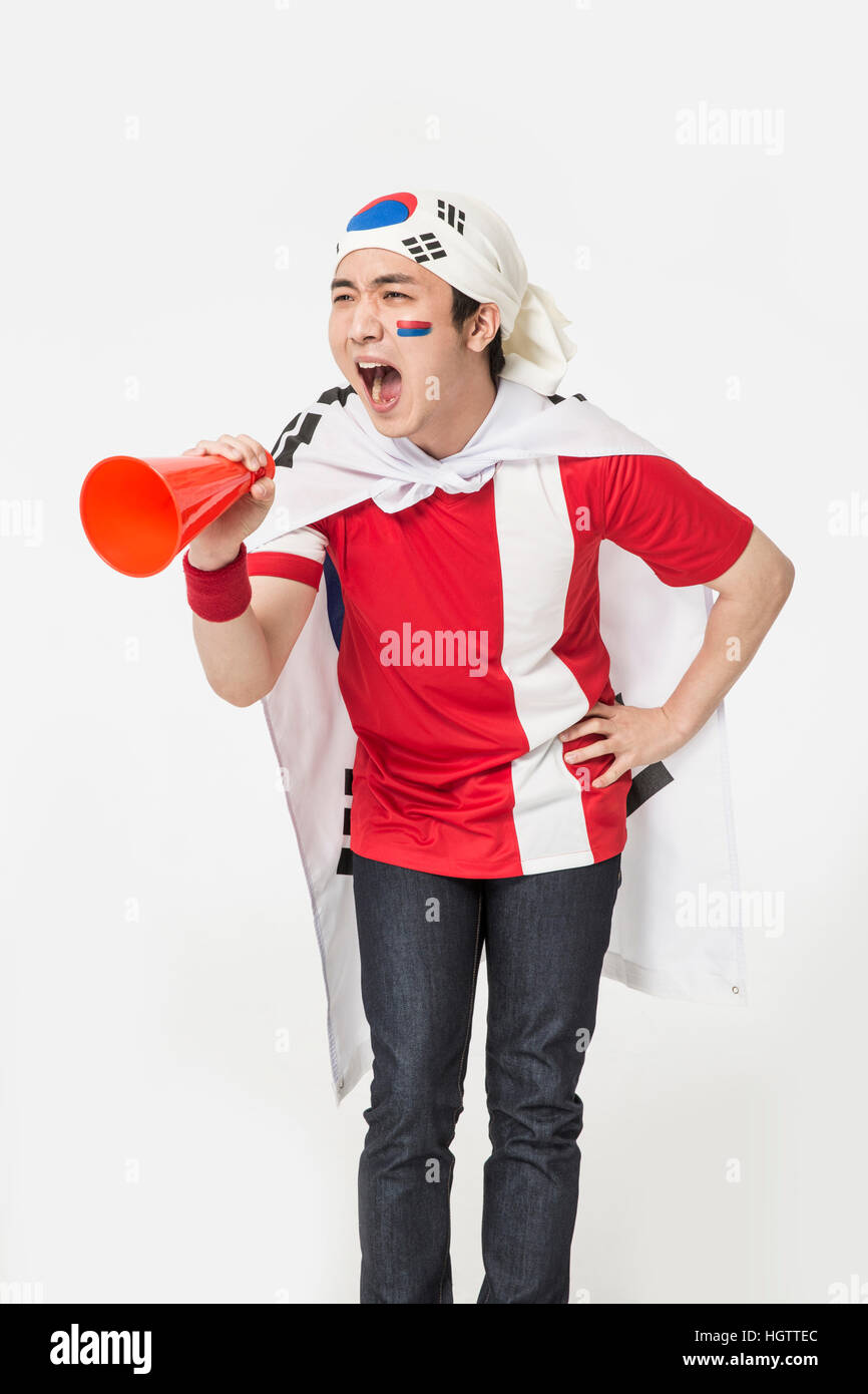 Jeune homme cheerleader coréen criant à travers un mégaphone Banque D'Images