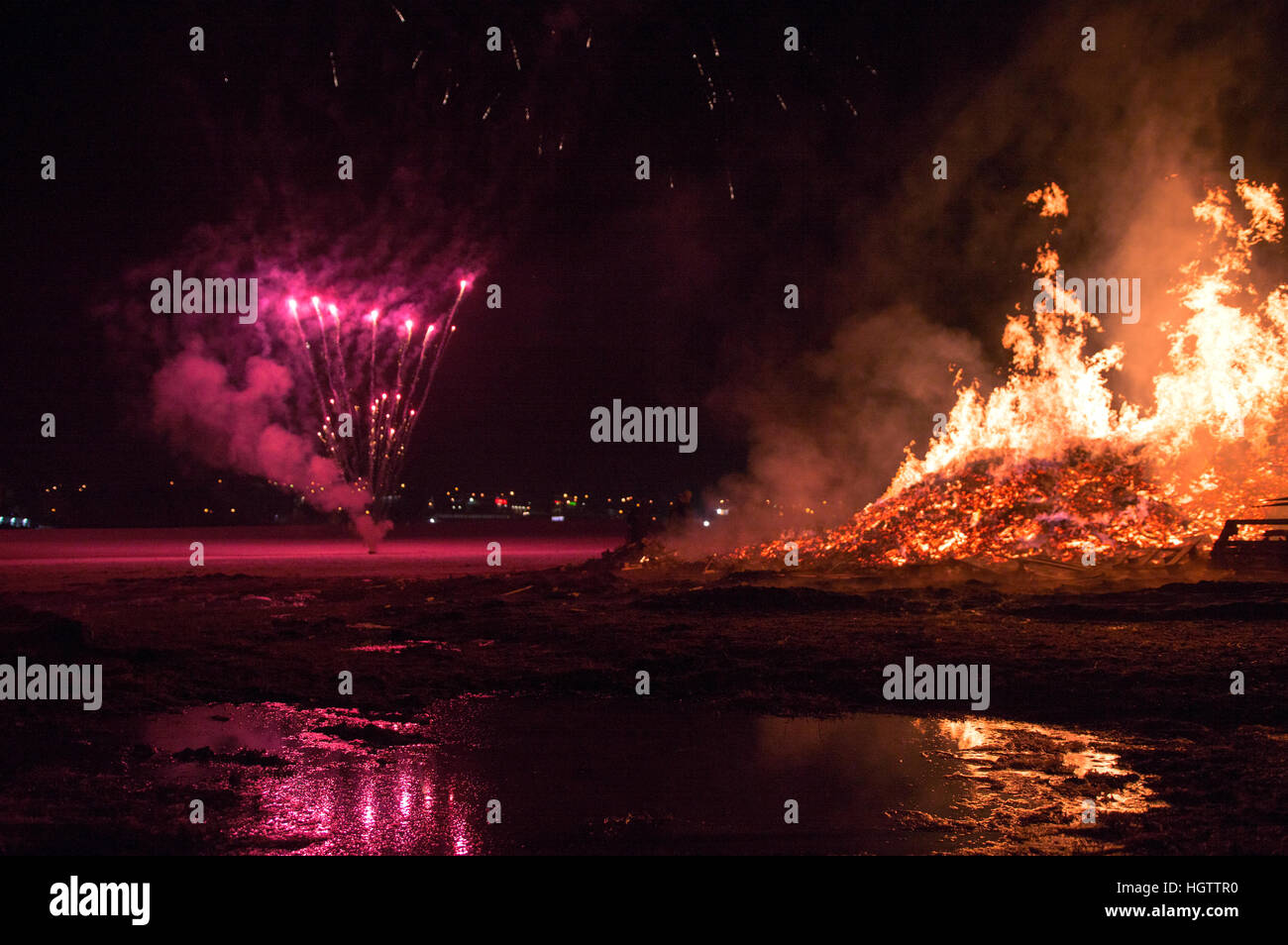 D'artifice exploser à côté d'un feu à une célébration du Nouvel An à Reykjavik, Islande Banque D'Images