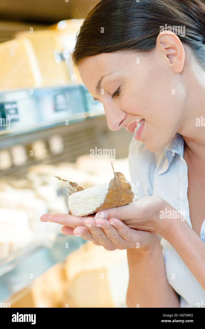 Jeune femme tenant un peu de fromage Banque D'Images