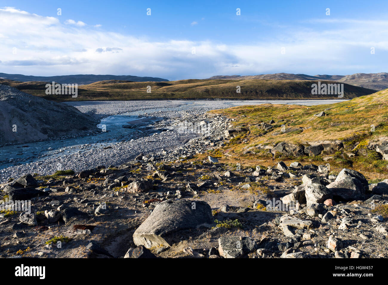 Une rivière qui coule le long de la zone de fracture d'un énorme glacier dans une plaine de la toundra. Banque D'Images