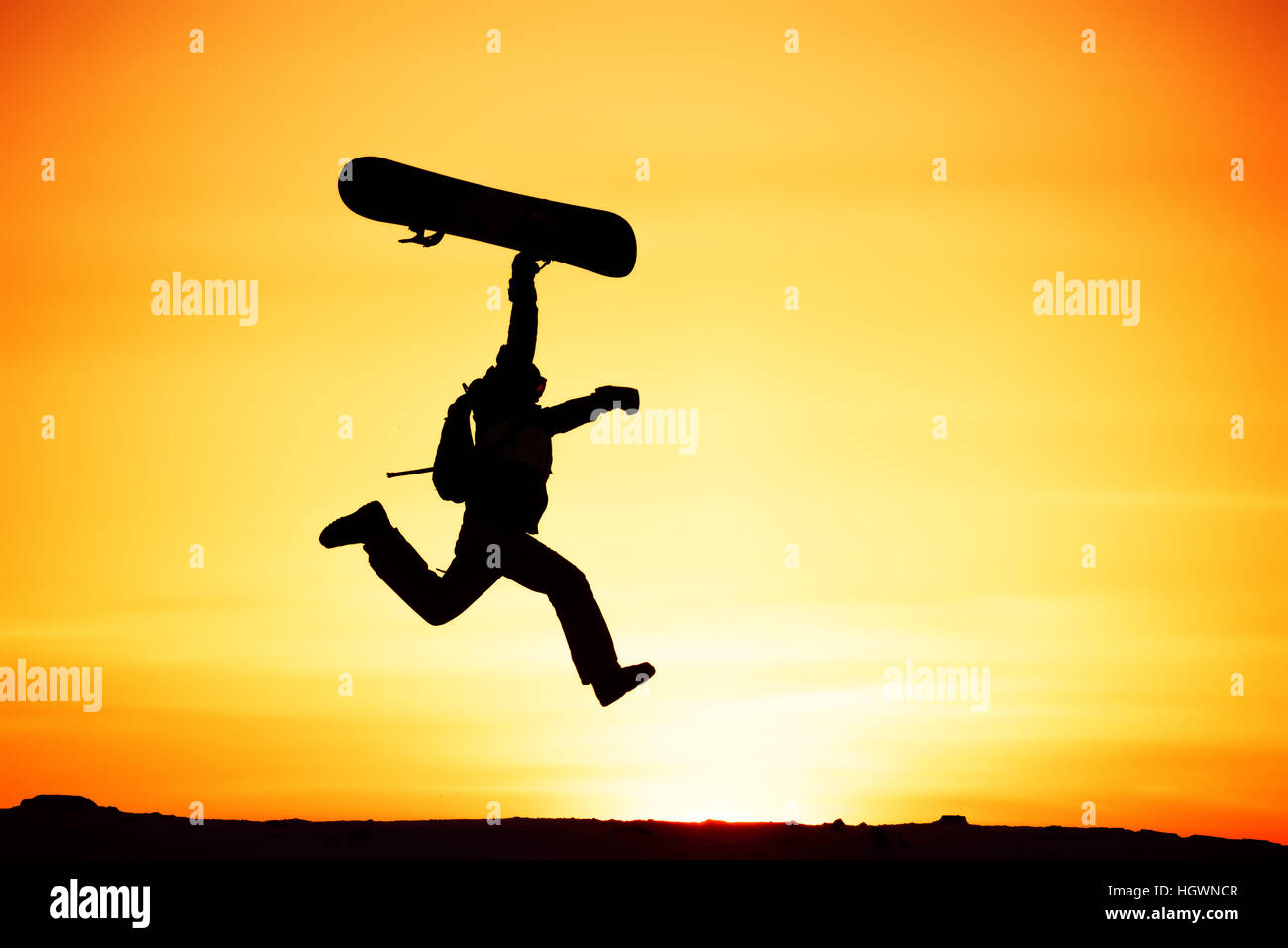 Heureux snowboarder jump ski au coucher du soleil Banque D'Images