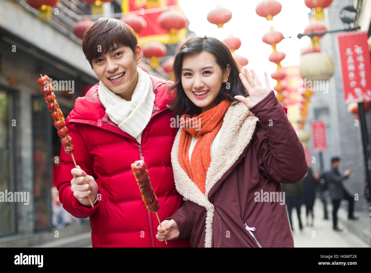 Jeune couple avec fruits confits haw célébrant le Nouvel An chinois Banque D'Images