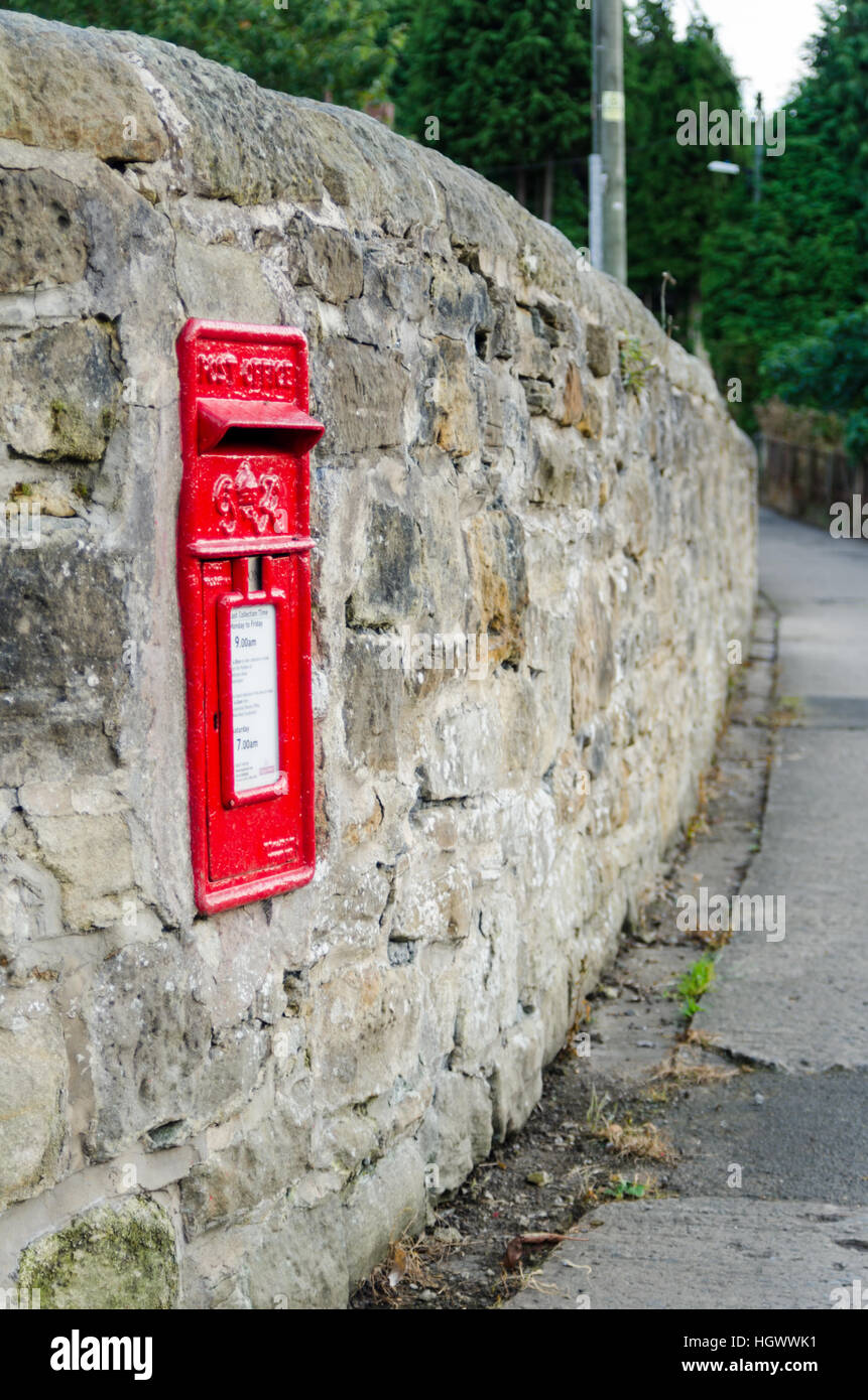 Un Rouge Royal Mail Postbox intégré dans un mur de pierre Banque D'Images